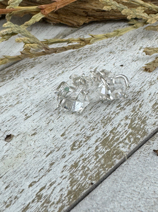 Herkimer diamond earrings on a rustic wooden surface