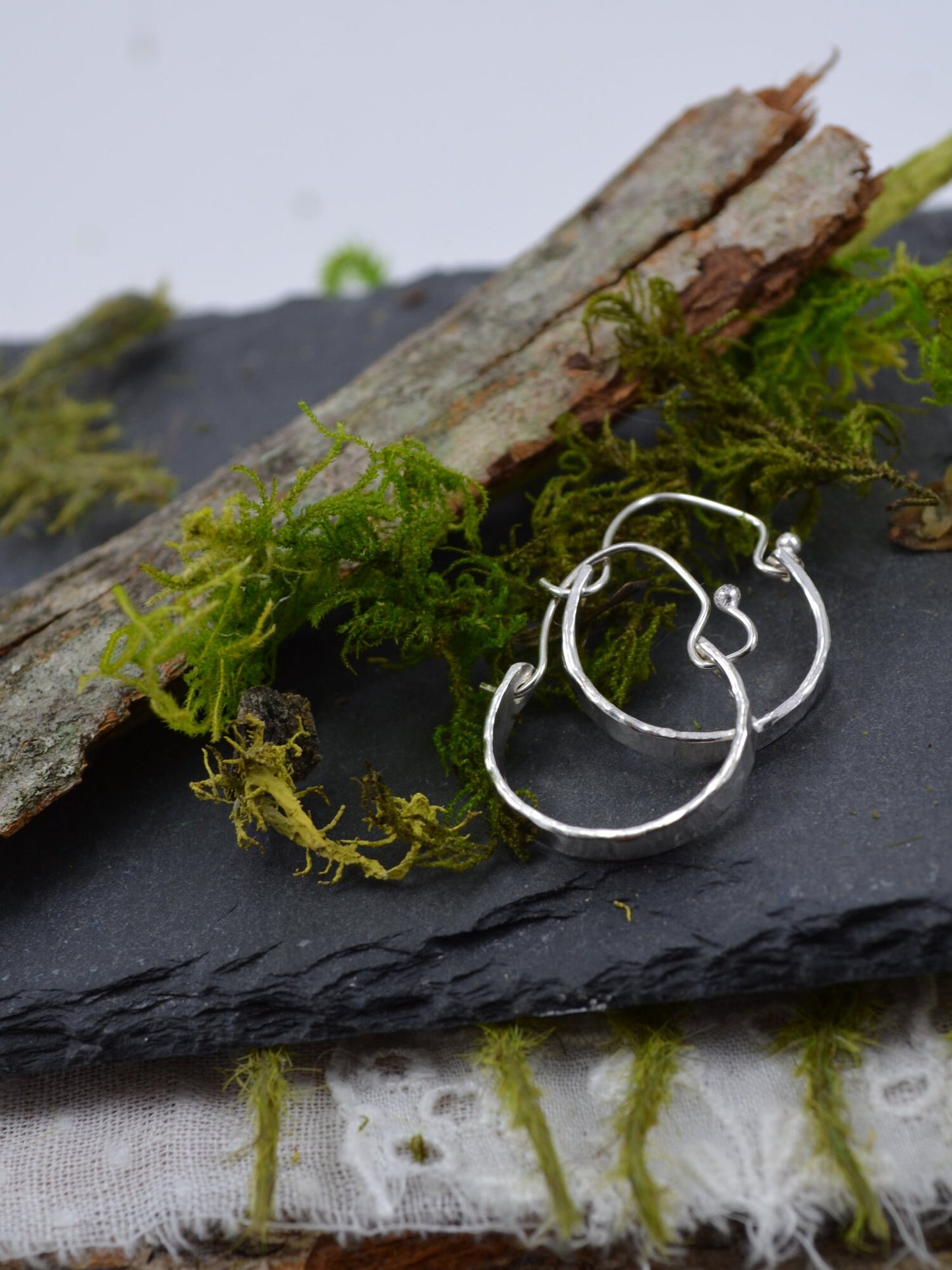 Sterling Silver Minimalist Hammered Hoops on slate with wood and moss accents