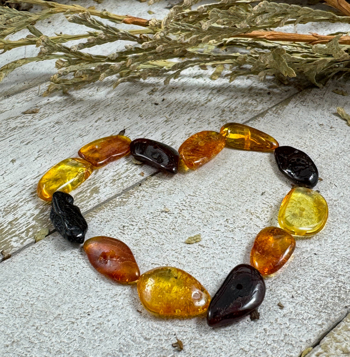 Baltic amber beads from Lithuania in different colors arranged in a heart shape.