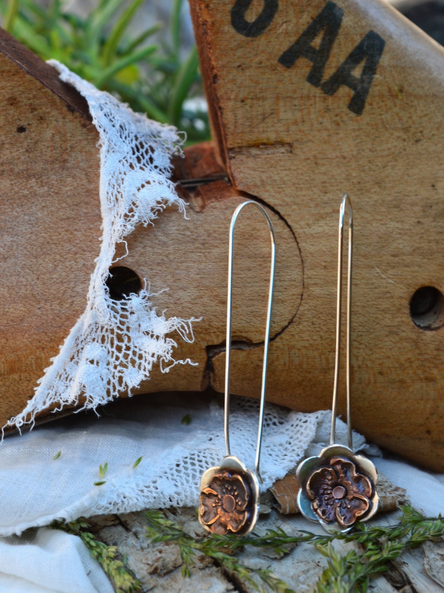 Gypsy Flower Earrings with Vintage Pansy on long earwire, displayed in front of a vintage shoe form