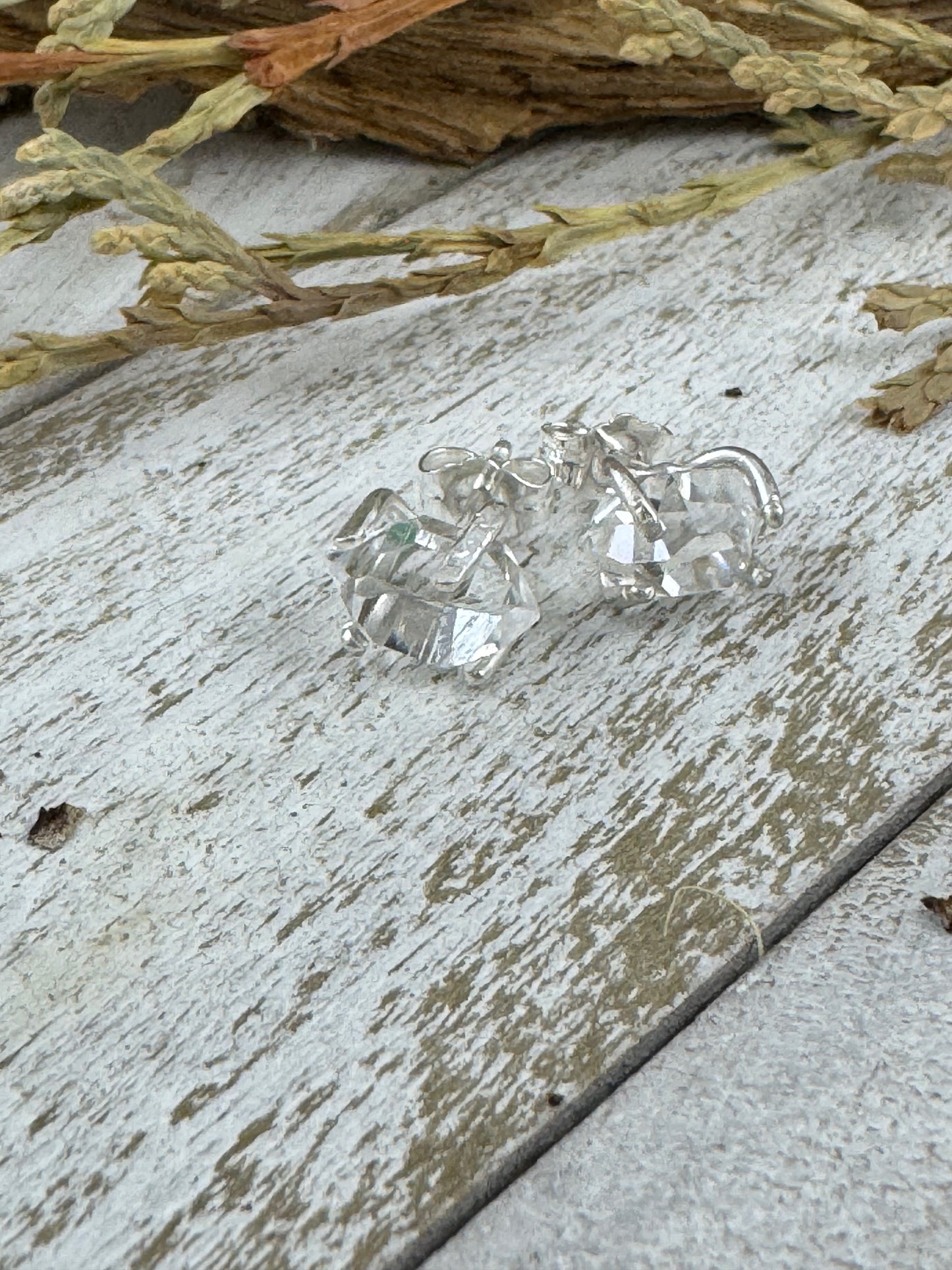 Herkimer diamond earrings on a rustic wooden surface