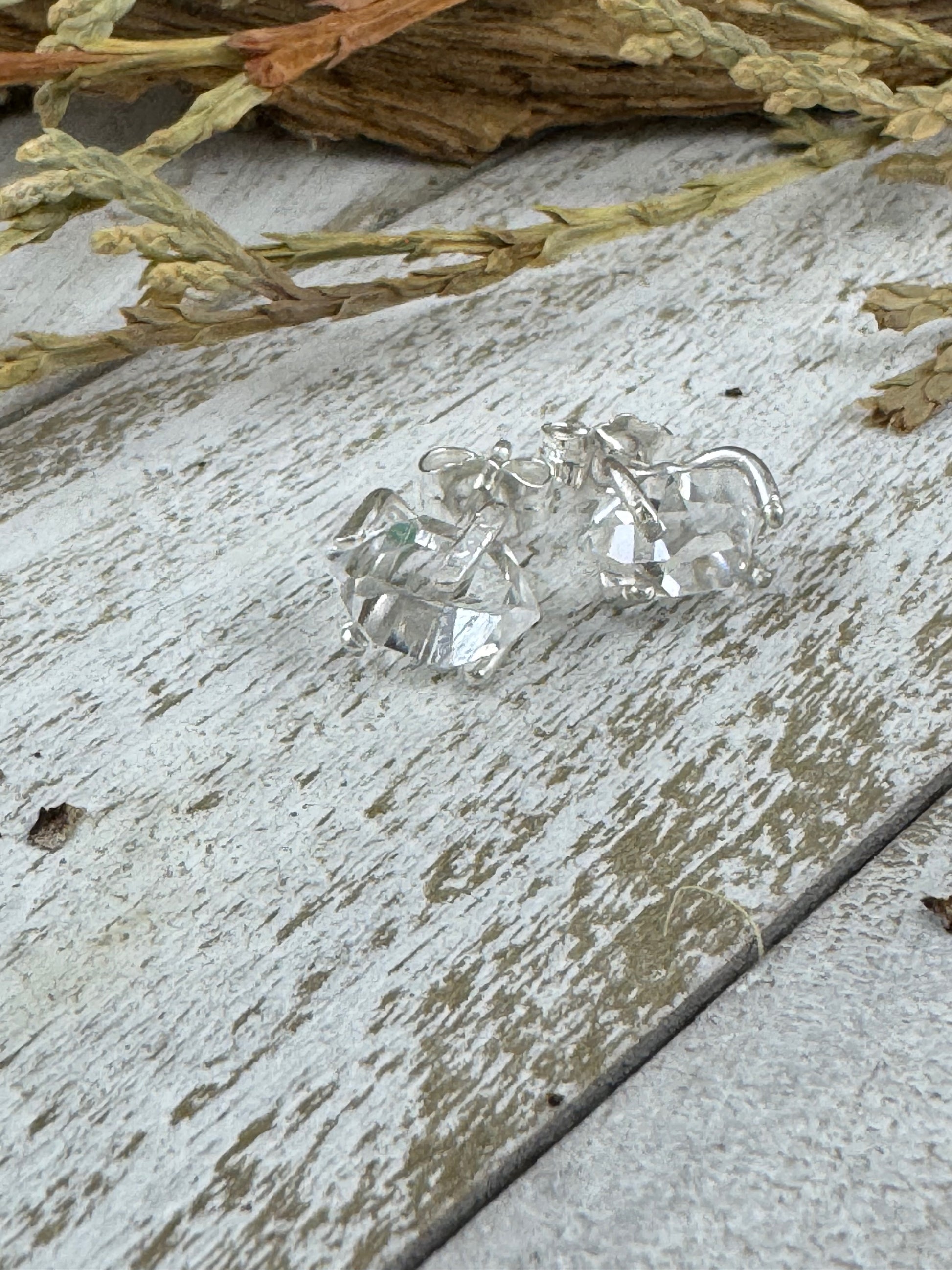 Herkimer diamond earrings on a rustic wooden surface